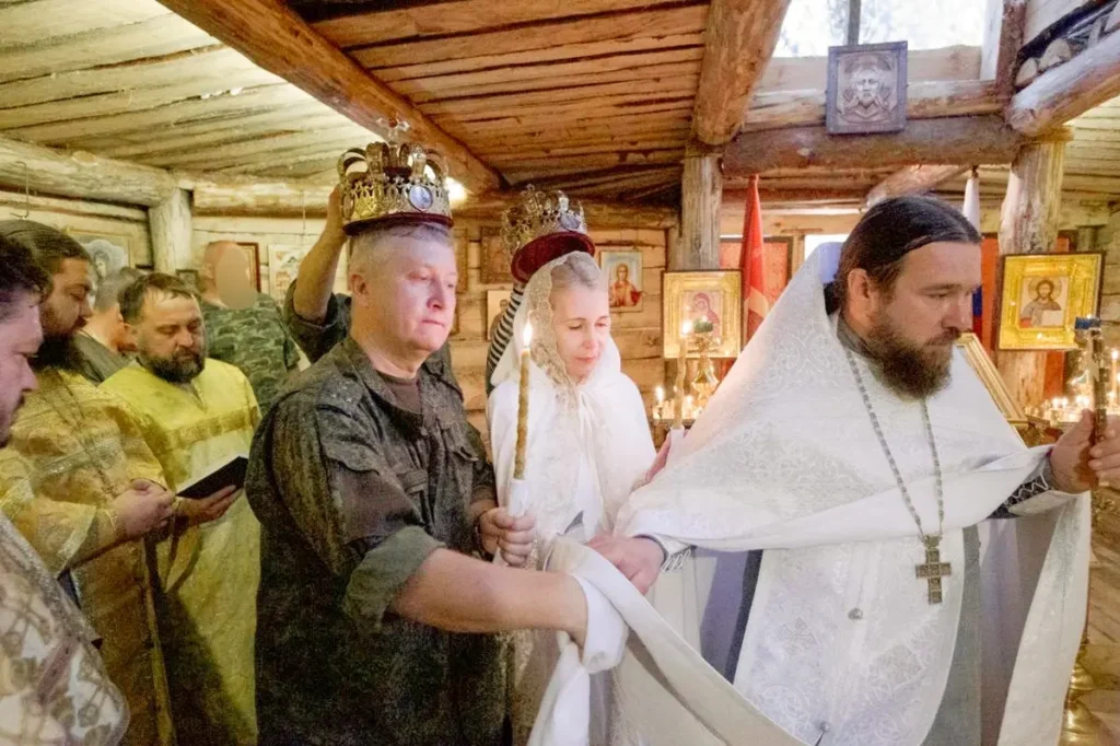 Священник Дмитрий Кротков проводит первый обряд венчания на фронте Евгения (военный медик) и Ирины в блиндажном храме на Херсонской направлении. Источник: канал «ZOV Сердца» в Telegram.